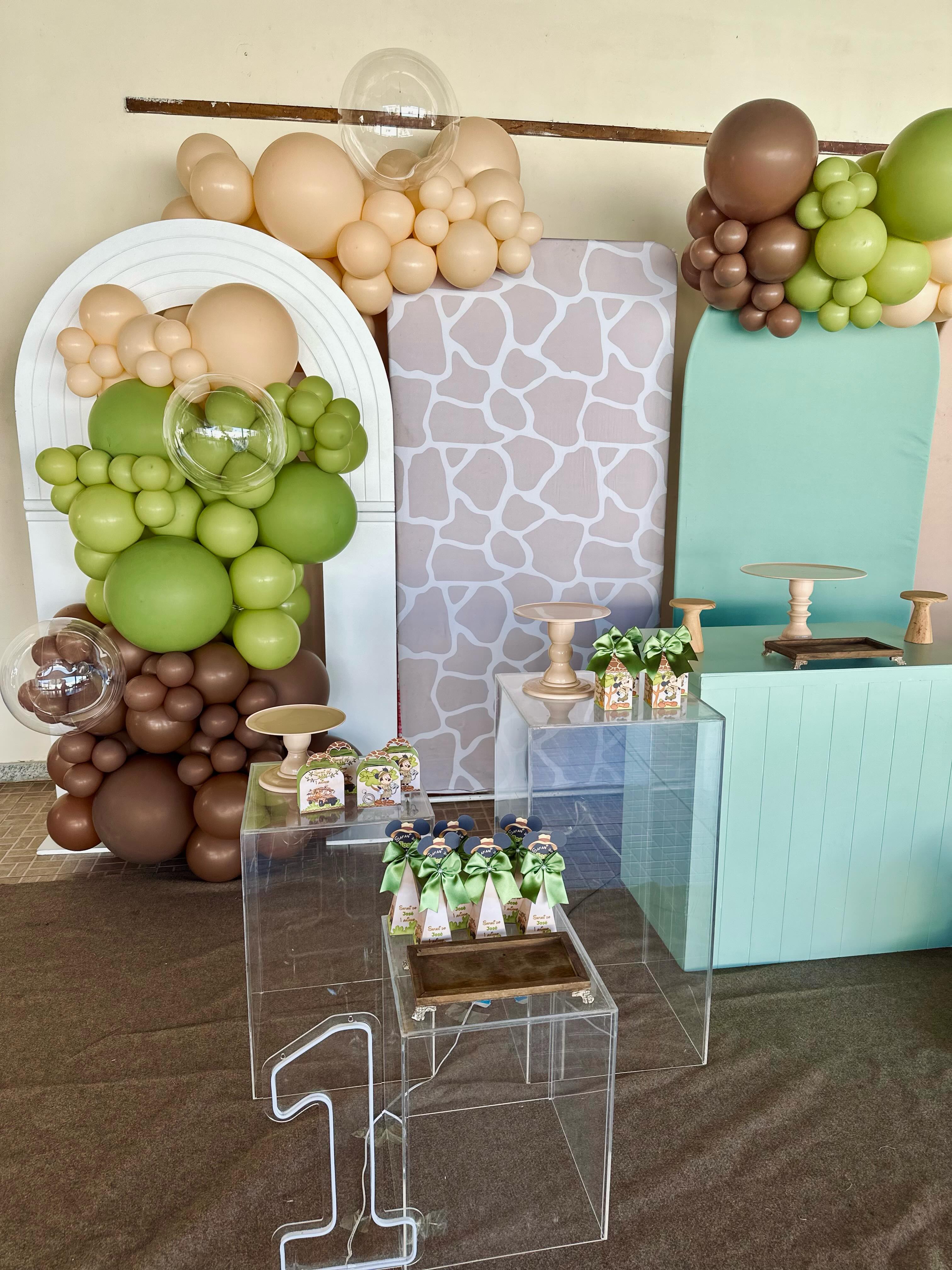Painel de aniversário infantil com arcos orgânicos de balões em tons de verde, bege e marrom, no tema safari.